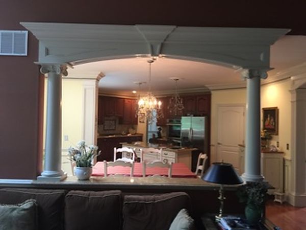 Arched opening with columns built and installed by DMM Carpentry, with crown molding in the kitchen beyond