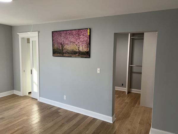 Gray bedroom with a trimmed frosted-glass door, a cased closet opening and white baseboard, installed by David