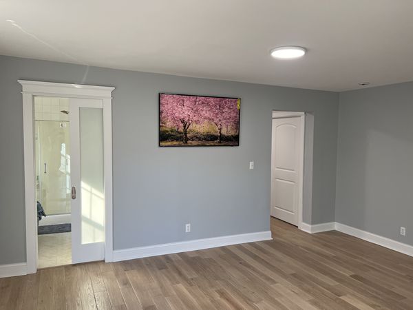 Gray bedroom with a frosted-glass sliding door under capped casing, a white arched-panel door and white baseboard, installed by David