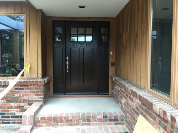 Dark entry door with glass lites and two sidelights at a brick porch, installed by David