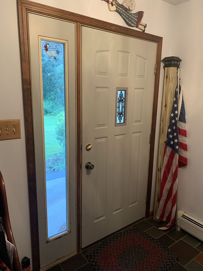The same entry door and sidelight closed, seen from inside with wood casing, installed by David