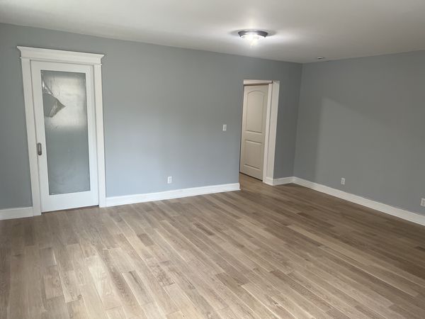 Frosted-glass interior door with capped head casing and white baseboard in a gray room, with a white panel door beyond, installed by David